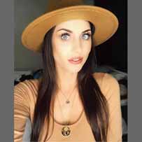 Testimonial Jess Paige millenial woman in light brown dress and head with long straight hear and bright blue eyes gold with black enamel pendant nesklace on her chest designed by ARY D'PO from Dream collection