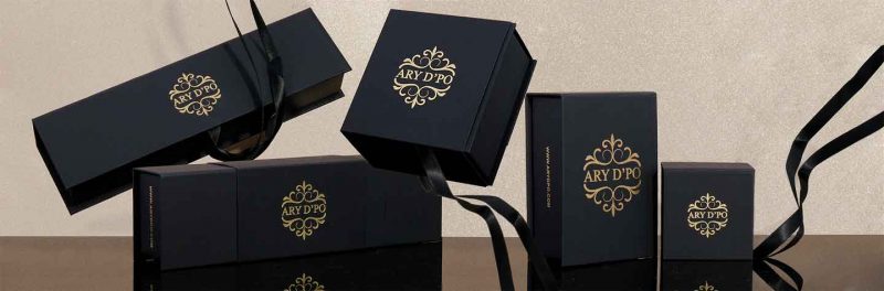 ARY D'PO Packaging and care. Various black boxes for jewelry with gold lead logos