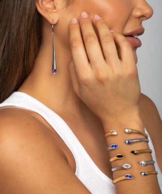 Beautiful woman with banded hand with ARY D'PO Urban Marquise Collection Mate Rhodium and gold Plated Lever back Earrings and cuff bracelets hinged with Swarovski crystals