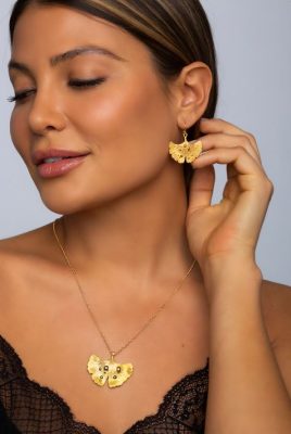 arydpo Ginkgo Leaf After Rain Jewelry Collection in gold presented by a beautiful model wearing a black top
