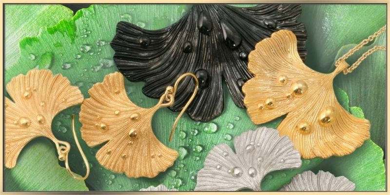 The ARY D'PO Ginkgo Leaf After Rain jewelry collection on the wet green leaves with droplets
