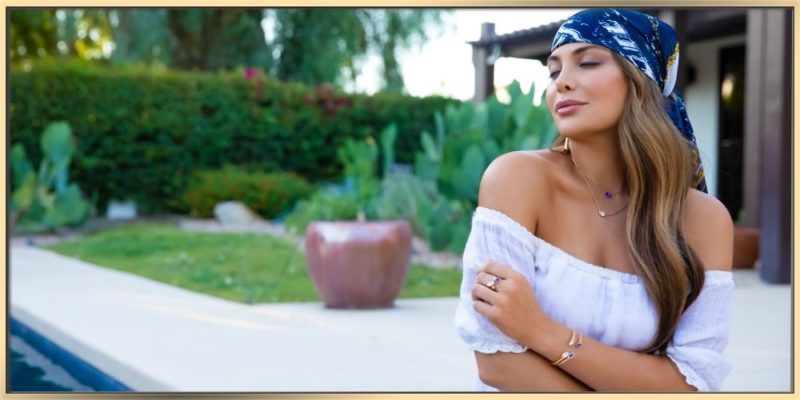 arydpo Urban Marquise jewelry collection showcased by Carly Diamond Stone wearing white summer dress and blue bandana while seating outside at the pool